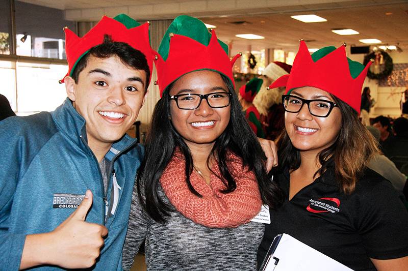 three students at the associated student's holiday celebration