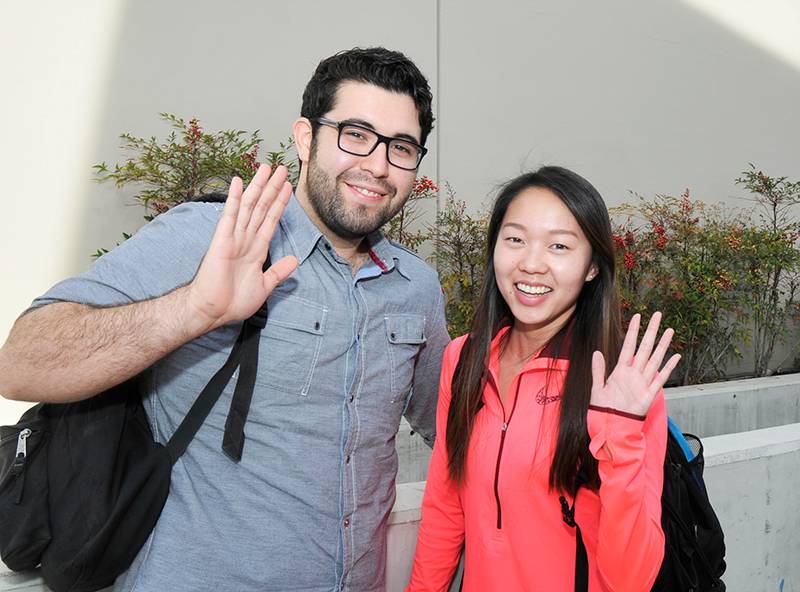 two students waving