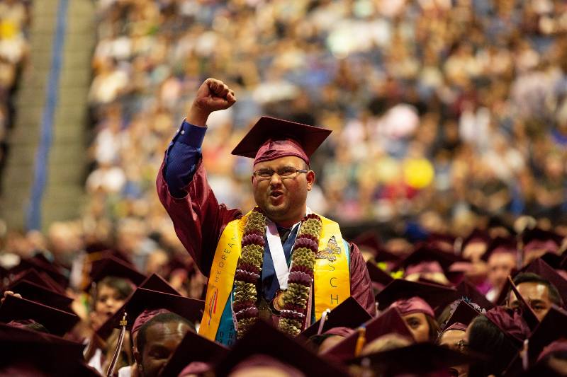 A graduate pumps his fist in excitement