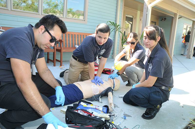 four paramedic students providing CPR during a drill