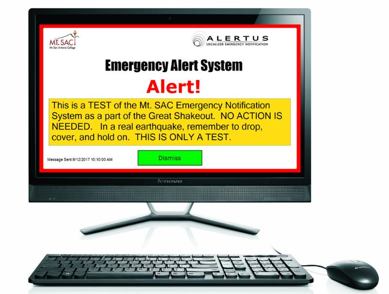 A computer with a desktop notification on its screen showing the Emergency Alert System.