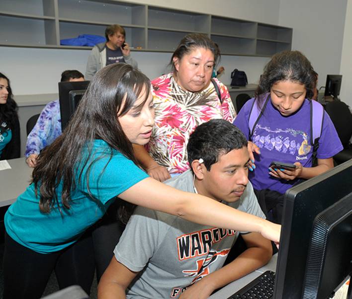 Staff helping students at computer