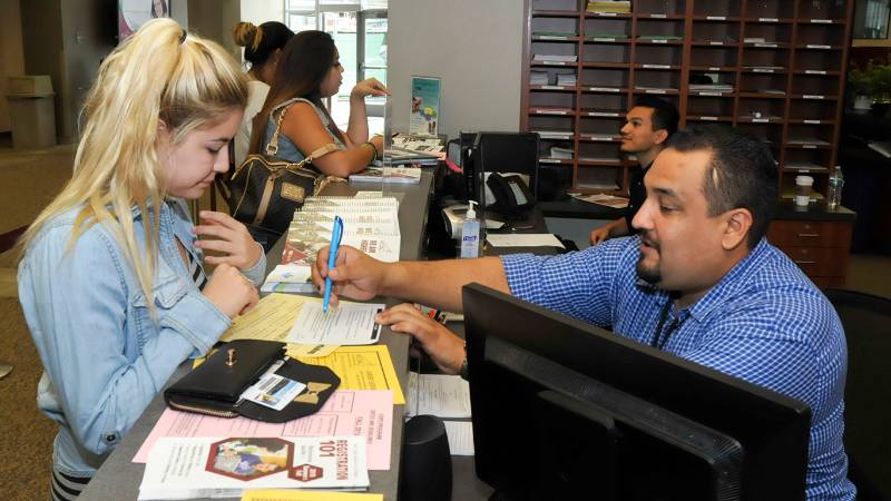 A staff member guides a new student during the first week of school in the Student Services Building.. 