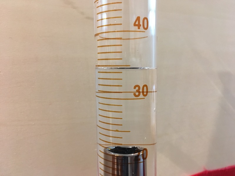 Volume reading on graduated cylinder with object for measurement