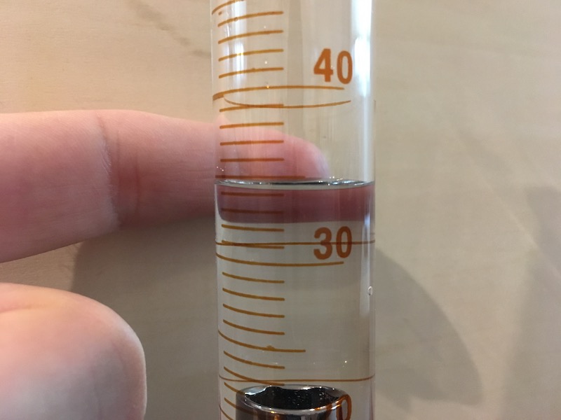 Volume reading on graduated cylinder with object and contrast for measurement