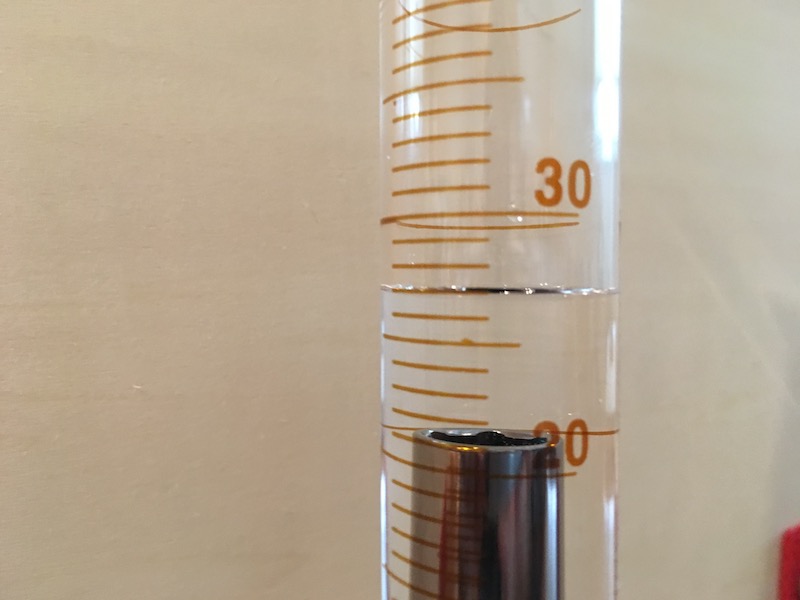 Volume reading on graduated cylinder with object for measurement