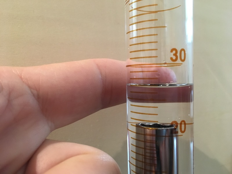 Volume reading on graduated cylinder with object and contrast for measurement