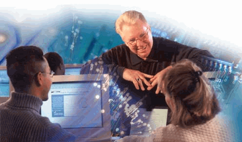 Picture of an instructor and two students in front of a computer screen