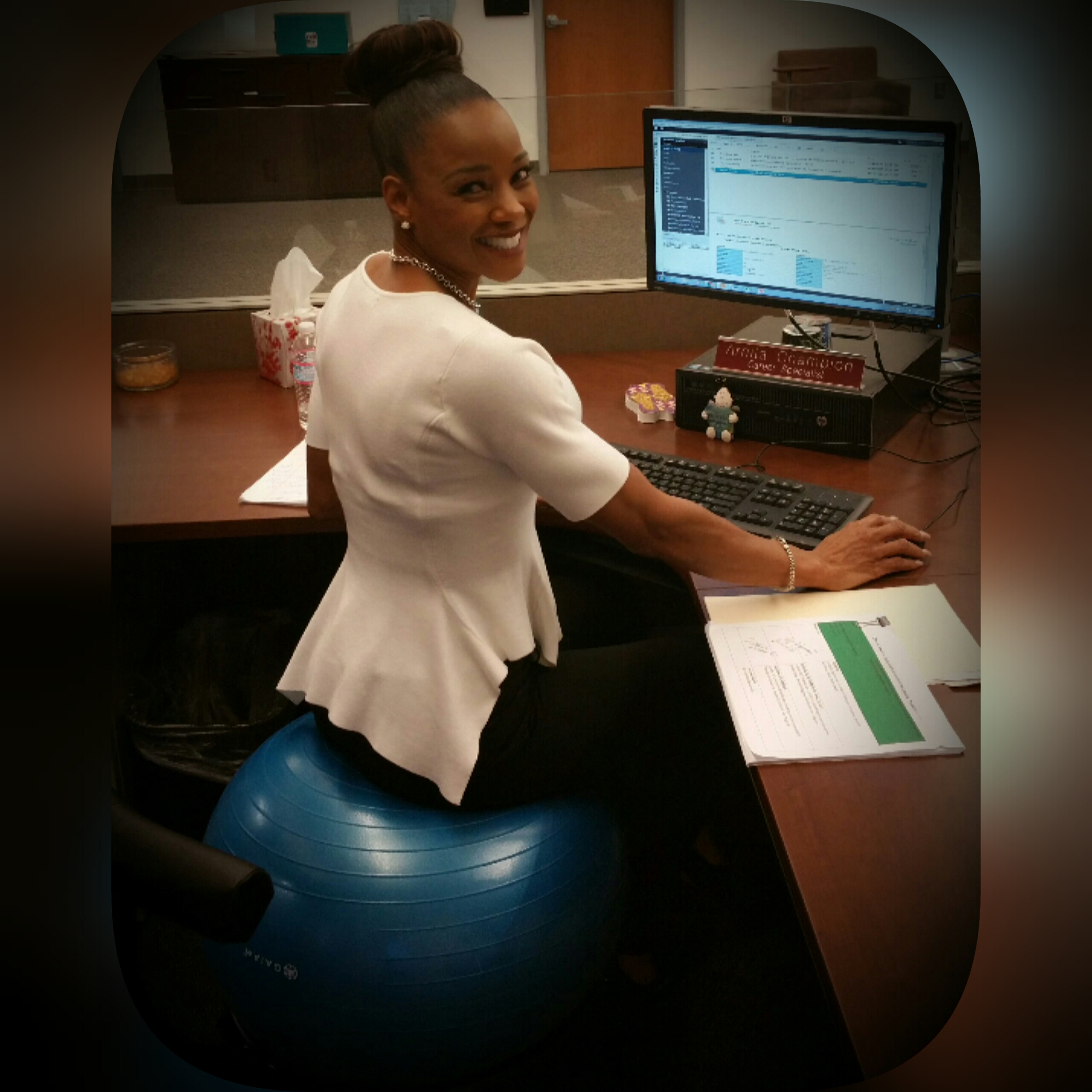 Arnita sitting on ball in office