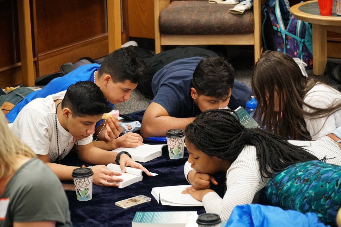 students laying on the floor reading books