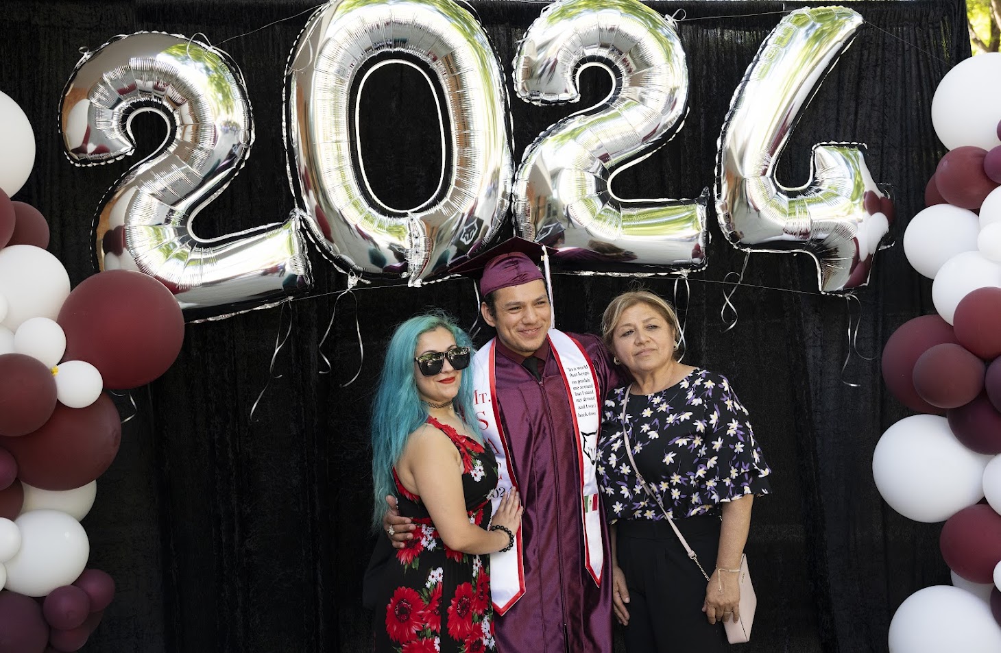 Adult Diploma grad with family at 2024 celebration