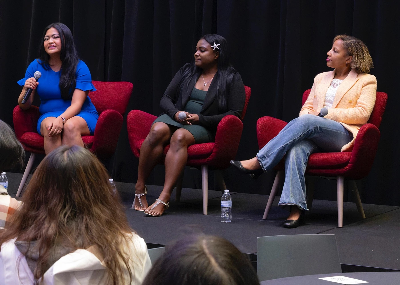 Women speak at a conference.