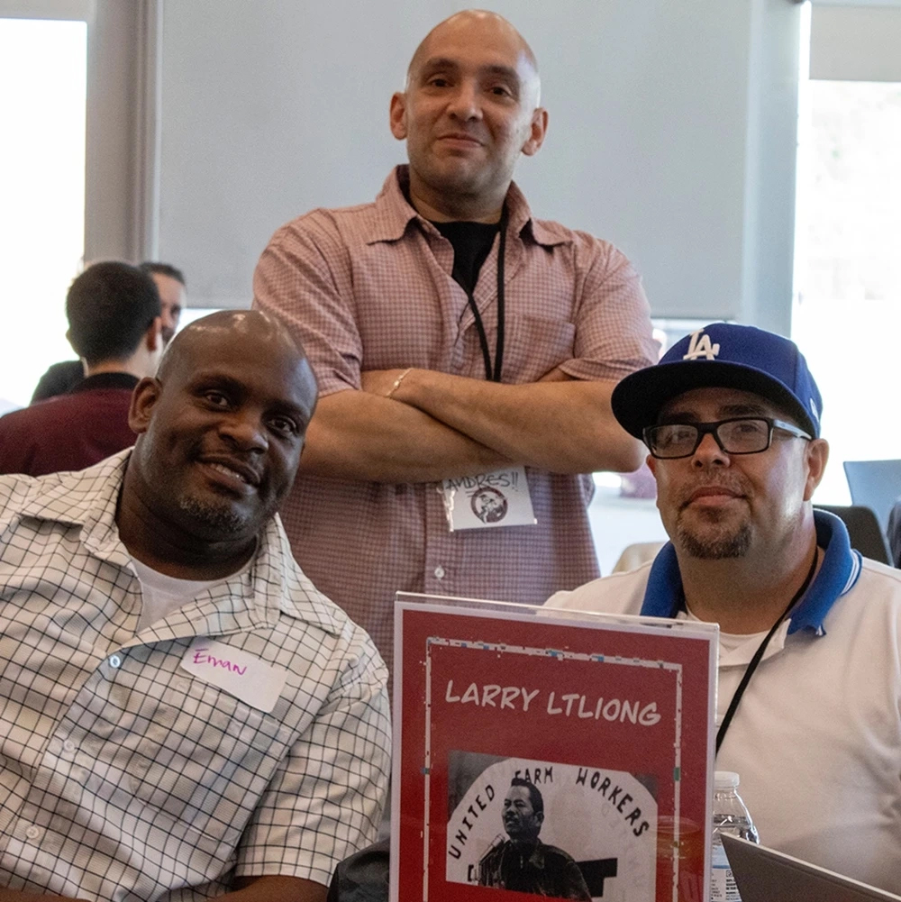 Three men at a MOCAN event take a moment to smile for the camera.
