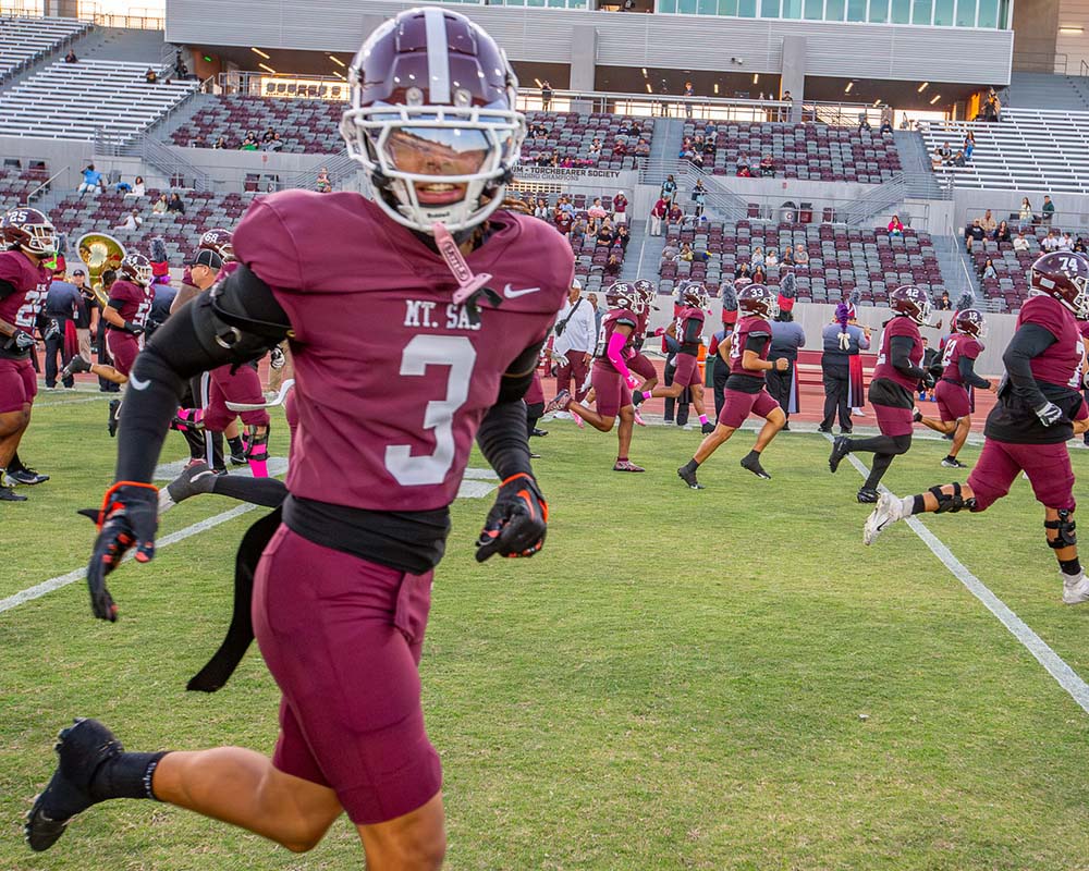 The Mt. SAC football team runs on the field at Hilmer Lodge Stadium.