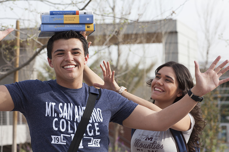 student balancing books on his head