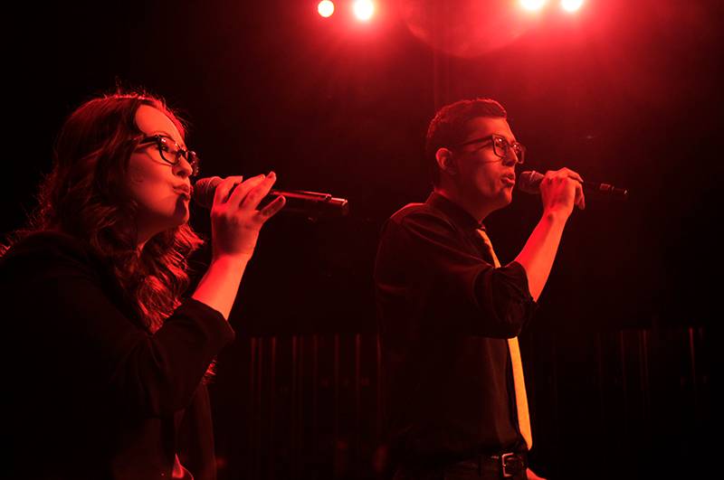 a man and a woman singing into mics