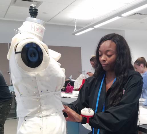 A fashion design student works with a dummy