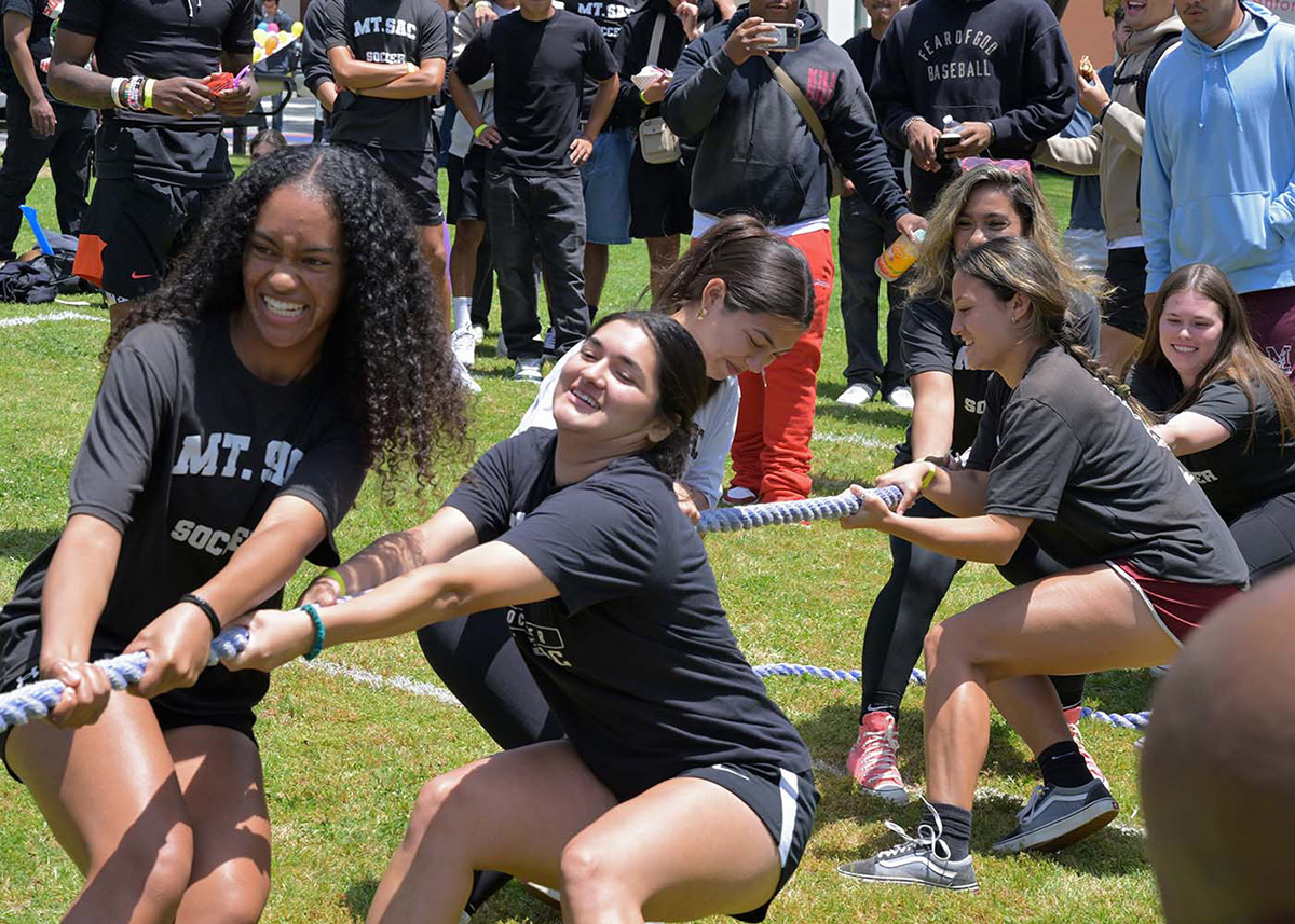 Students compete in a game of tug-of-war on campus.