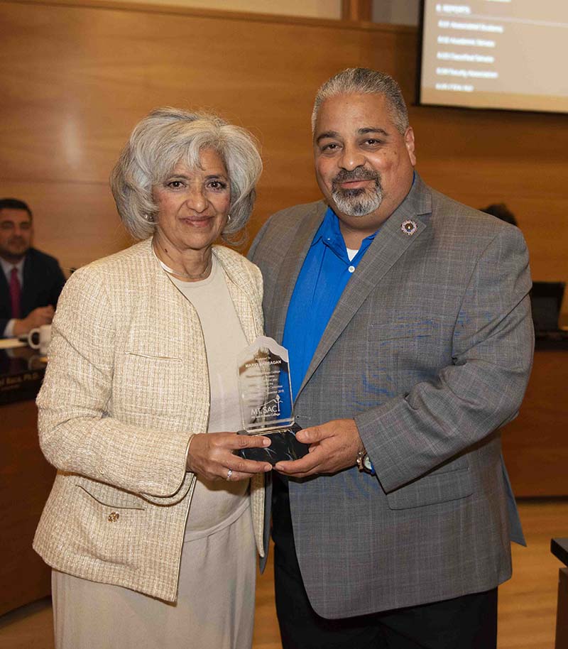 Board President Laura Santos awards Mario Barragan