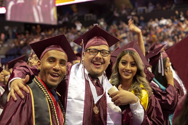 Three graduates posing at commencement