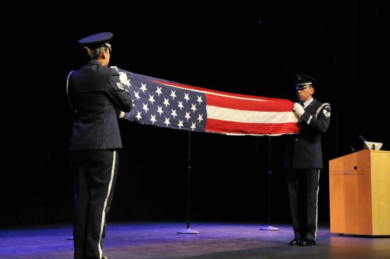 Air force representatives hold a flag folding ceremony