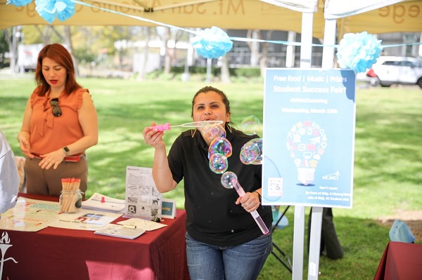 Woman blowing bubbles at booth