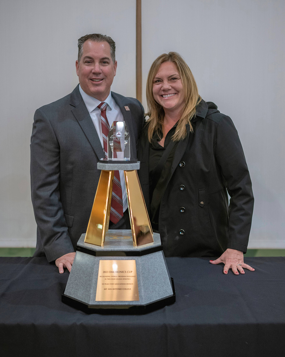 Joe Jennum and Tammy Knott-Silva smile with an award.