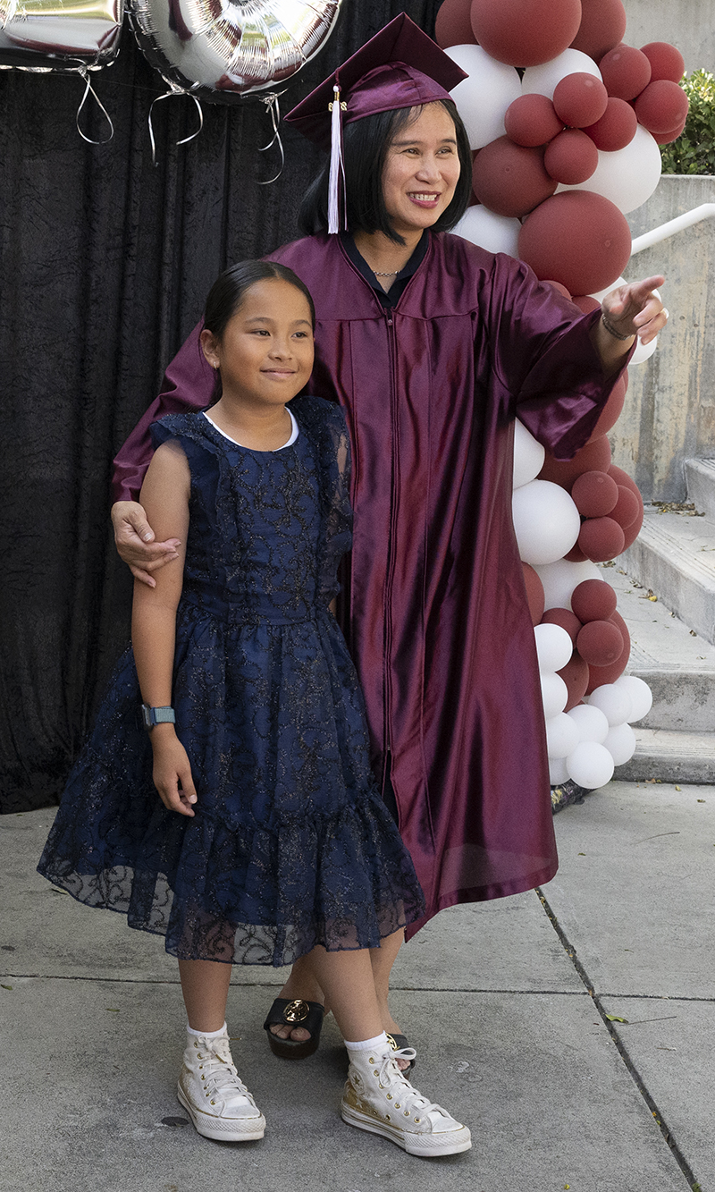 A Mt. SAC graduate and her young relative pose for a photo at a ceremony.