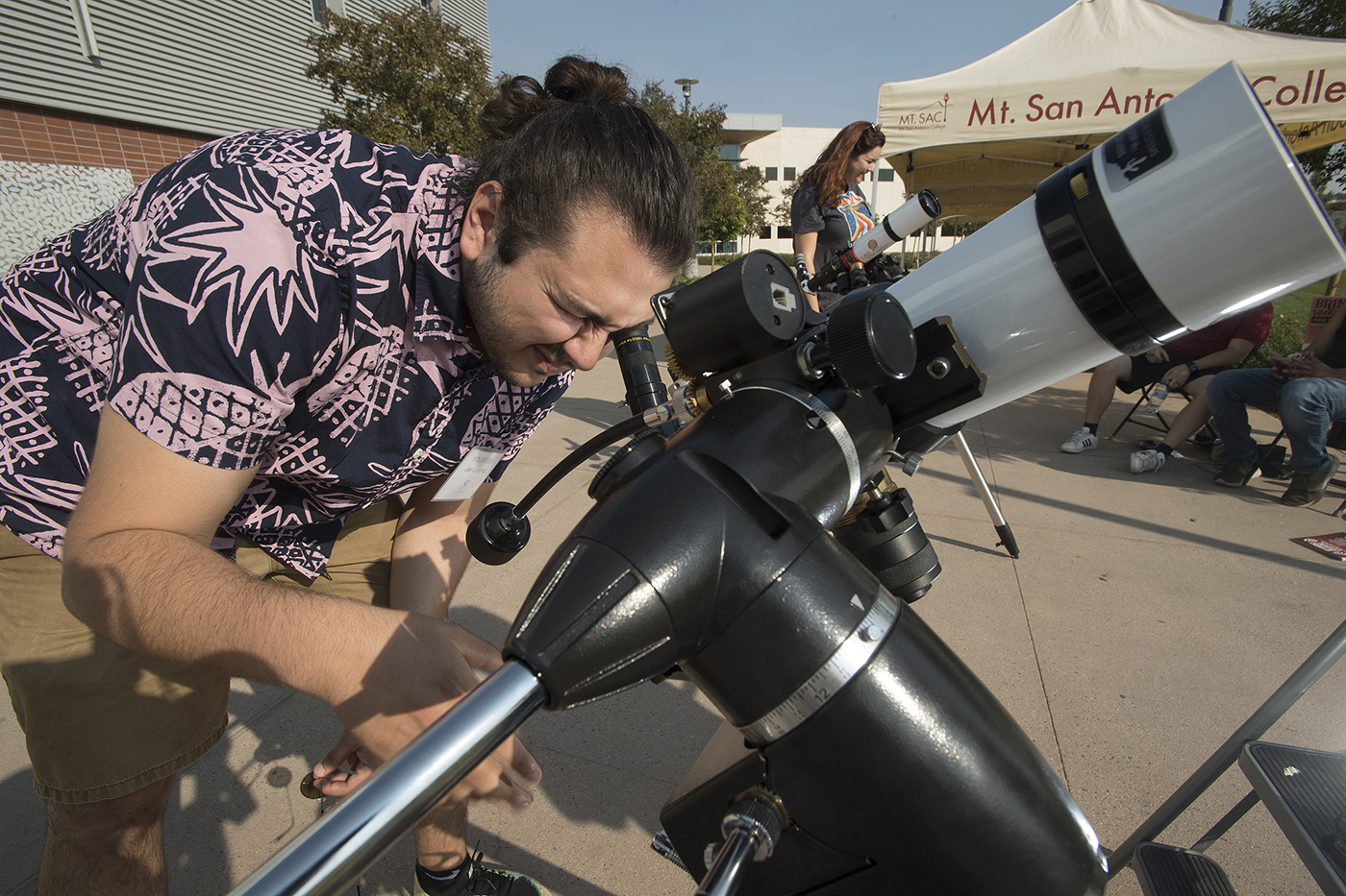 Student looking through a telescope.