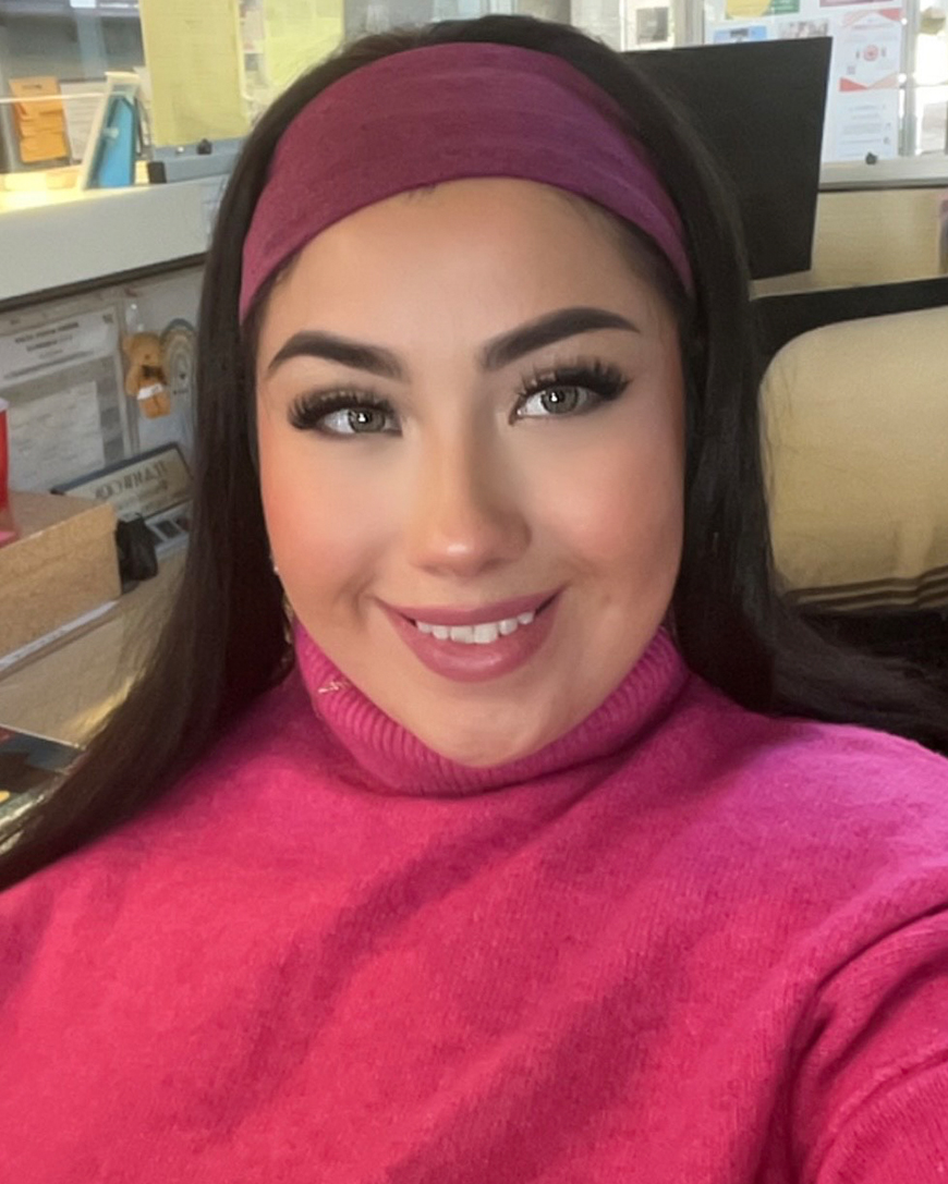 Alondra Munguia works at an office desk.