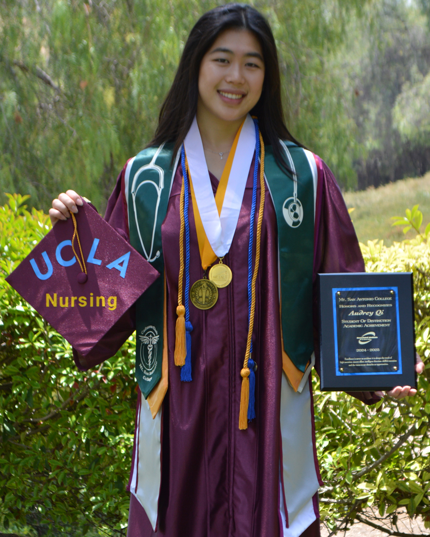 Audrey Qi holding up her graduation cap and an award.