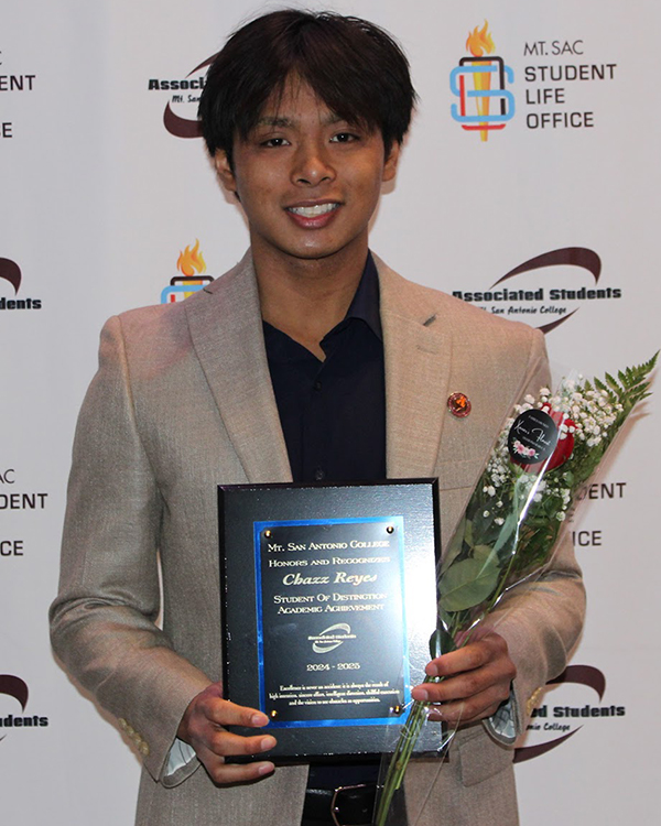 Chazz Reyes holds up a scholarship award.