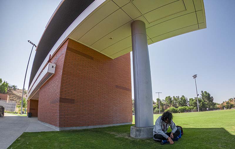 Student in shadow of Stadium digital sign