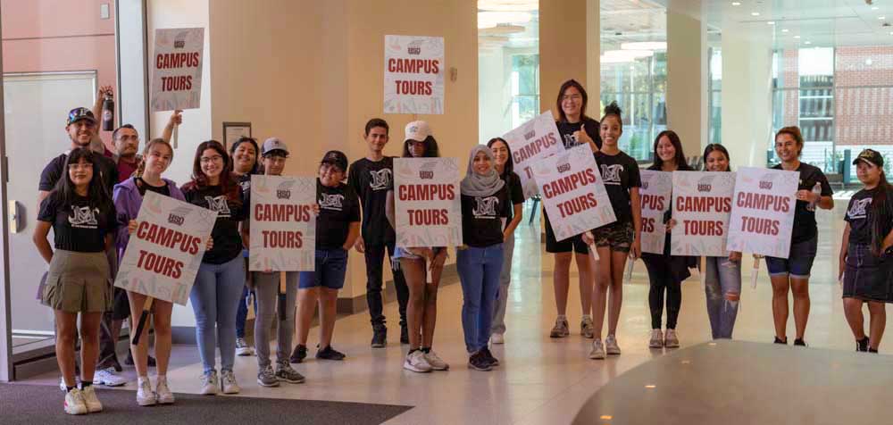 Student Ambassadors hold their "Campus Tours" signs