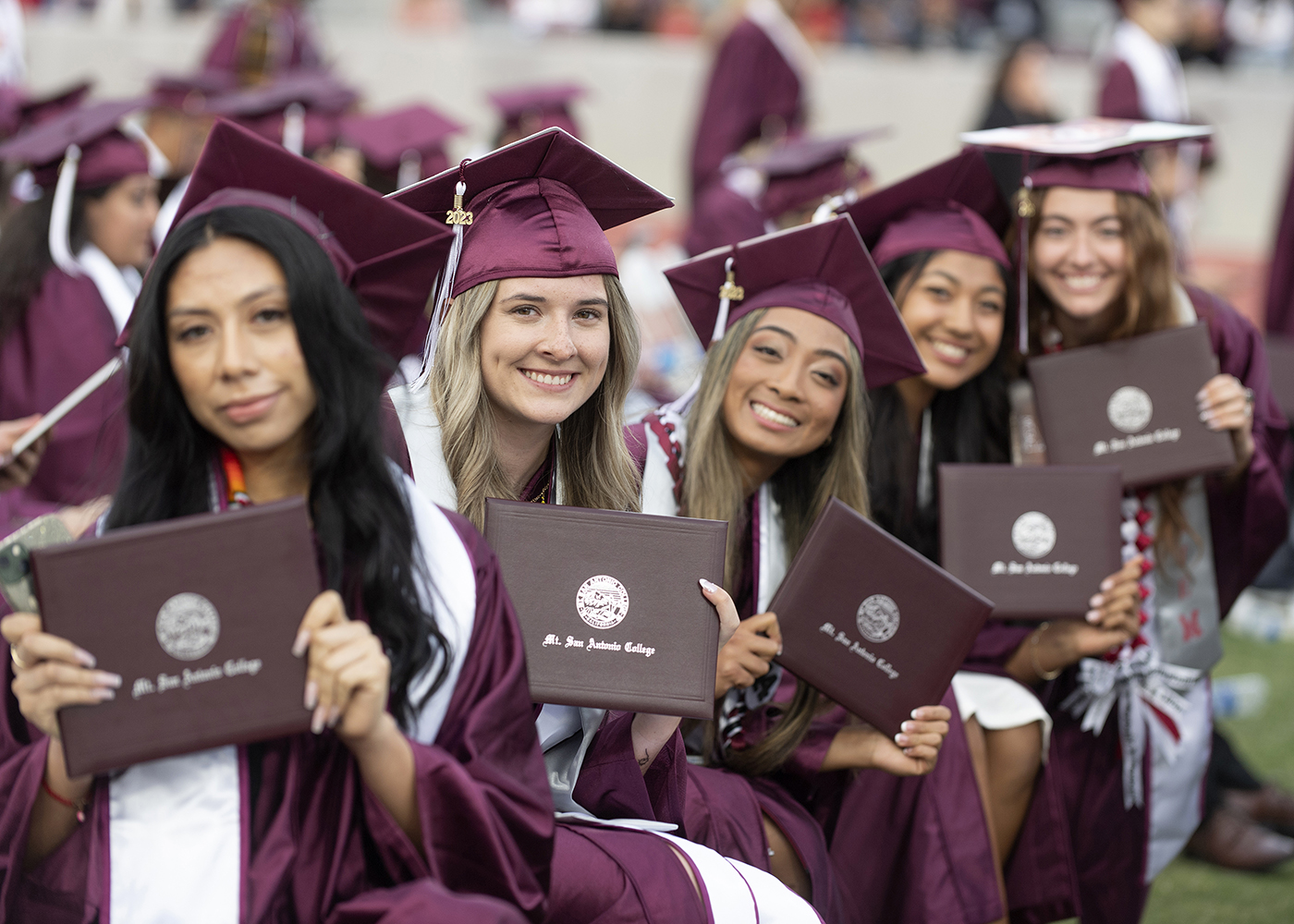 Mt. SAC graduates hold up diplomas. 