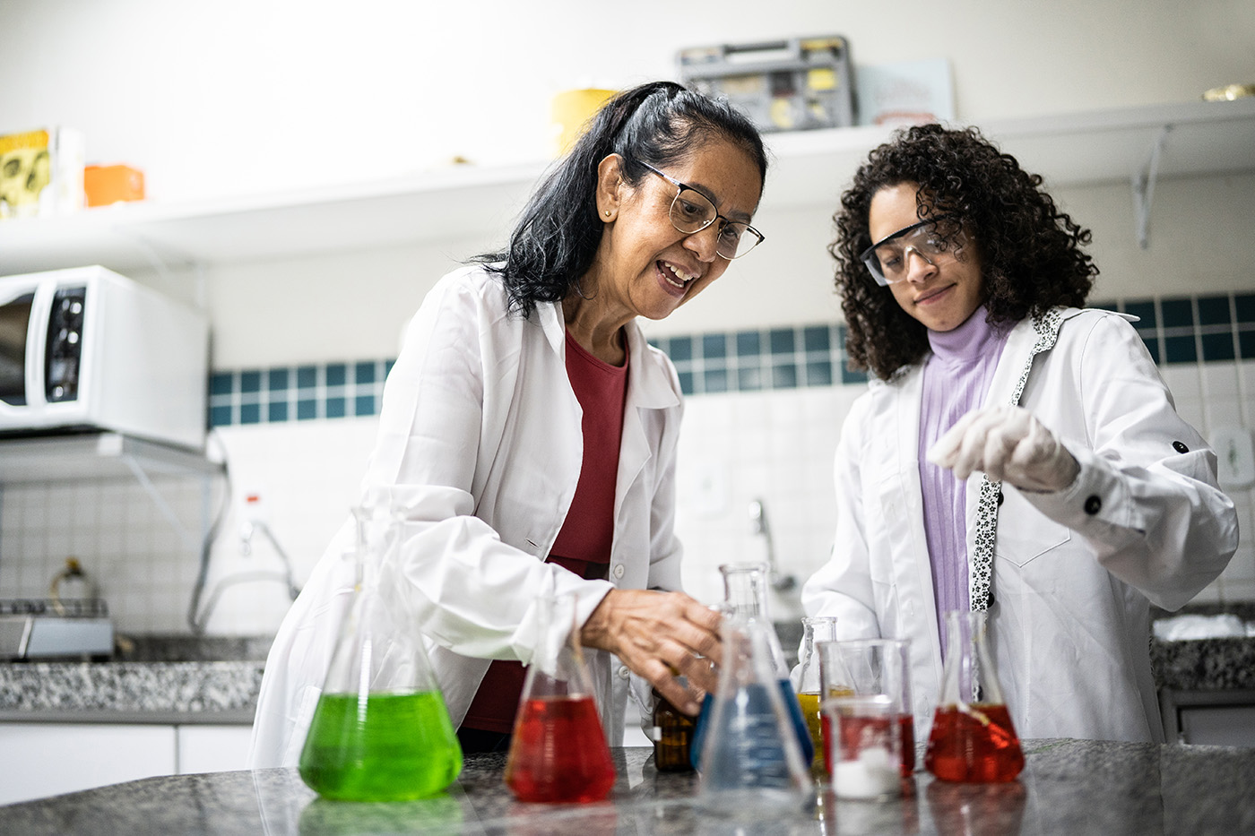 Two female scientists conduct an experiment in a lab.