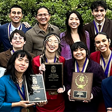 Students on the Speech and Debate Team hold up awards.