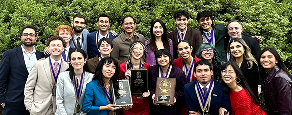 Students on the Speech and Debate Team hold up awards.