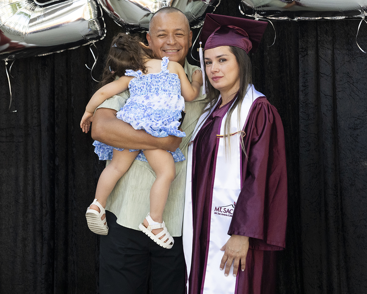 A family of three poses for a photo at a Mt. SAC graduation.