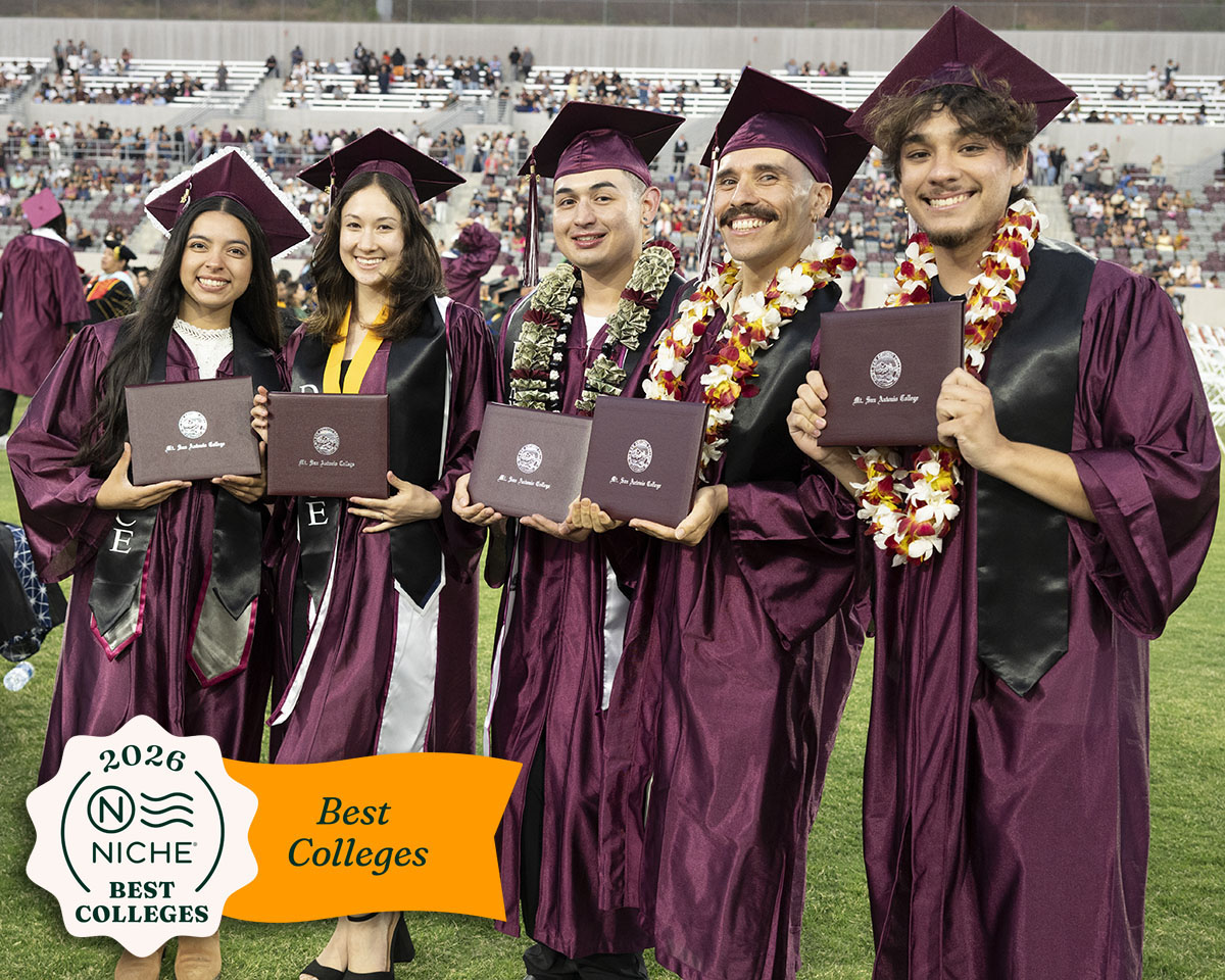 Graduates hold up their degrees are commencement in 2025.