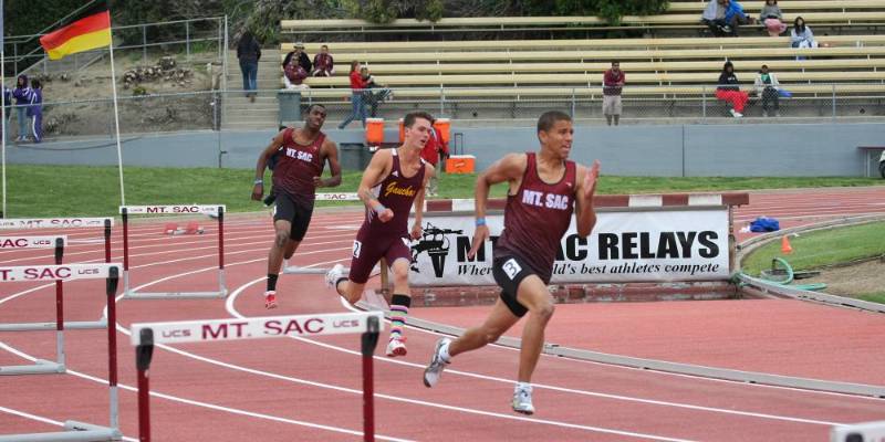 Three runners round the track