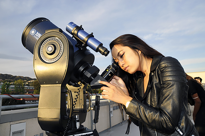 Student looking through telescope