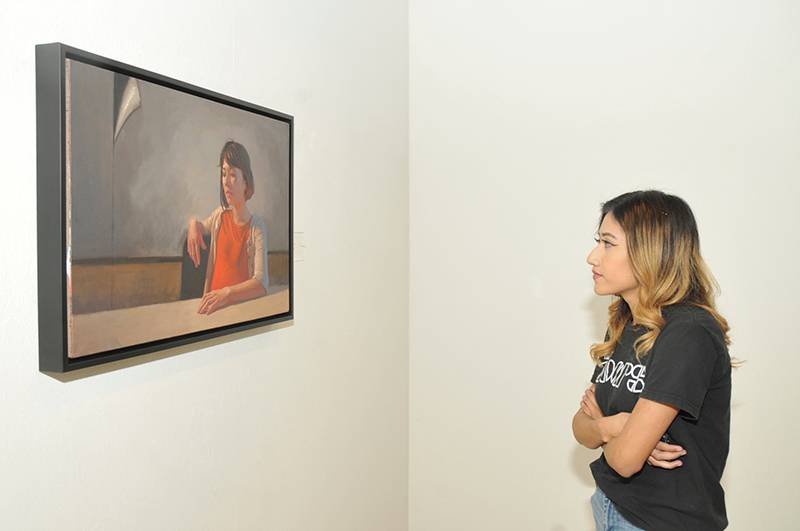 girl looking at painting