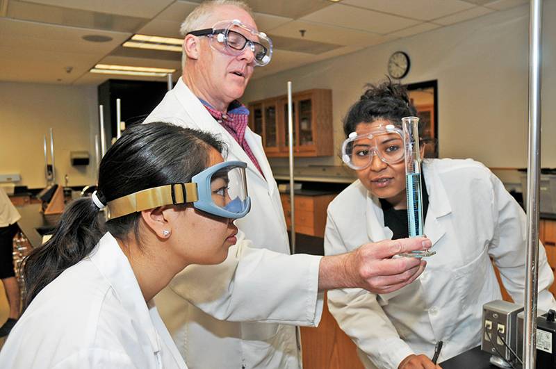 two students with chemistry professor