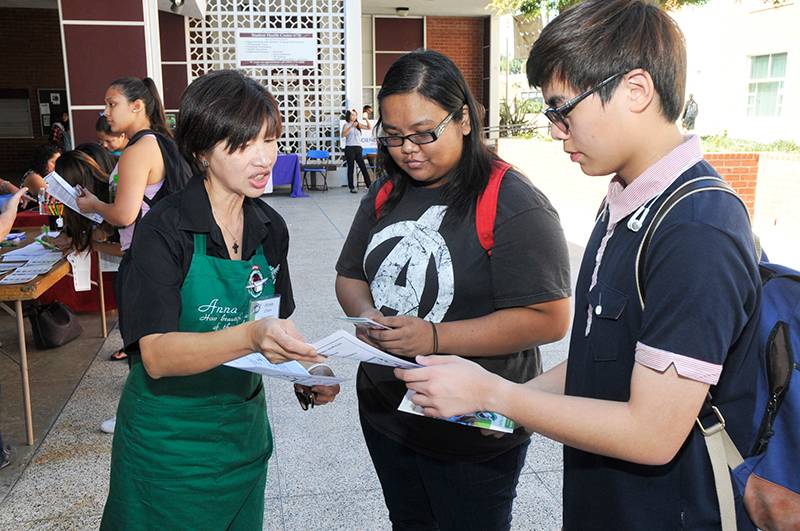 image of a vendor providing information to two students at a previous volunteer fair
