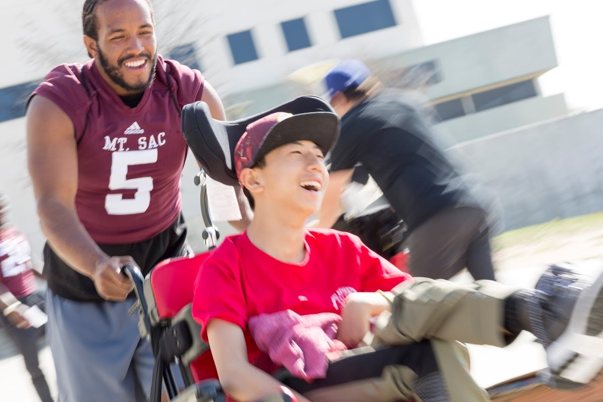 Man pushing child in wheelchair