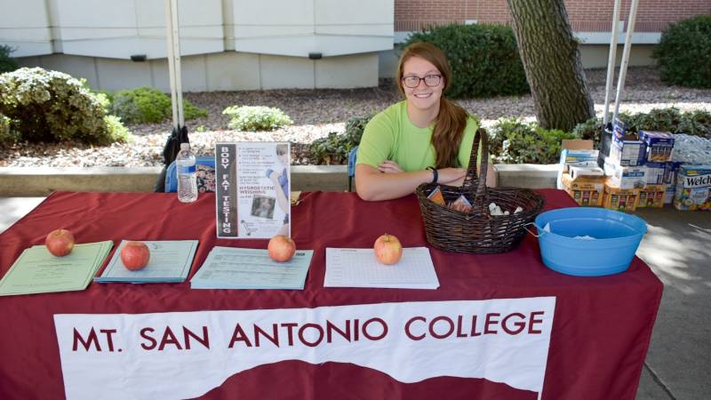 Student at information table with apples