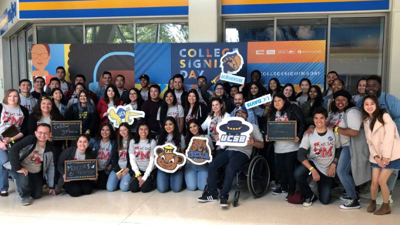 Students holding college signs