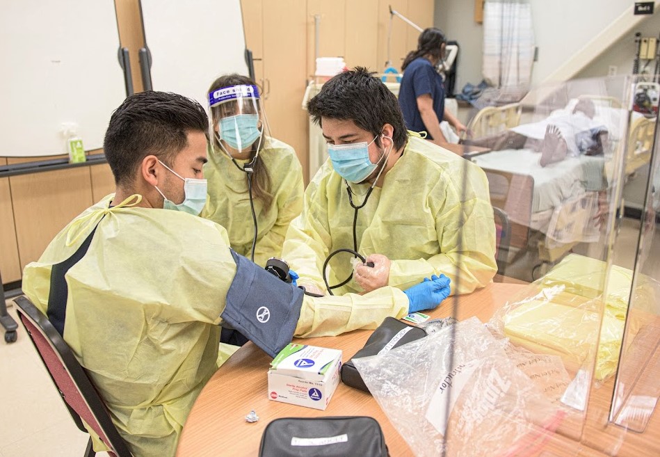 A nursing student practicing techniques on another student