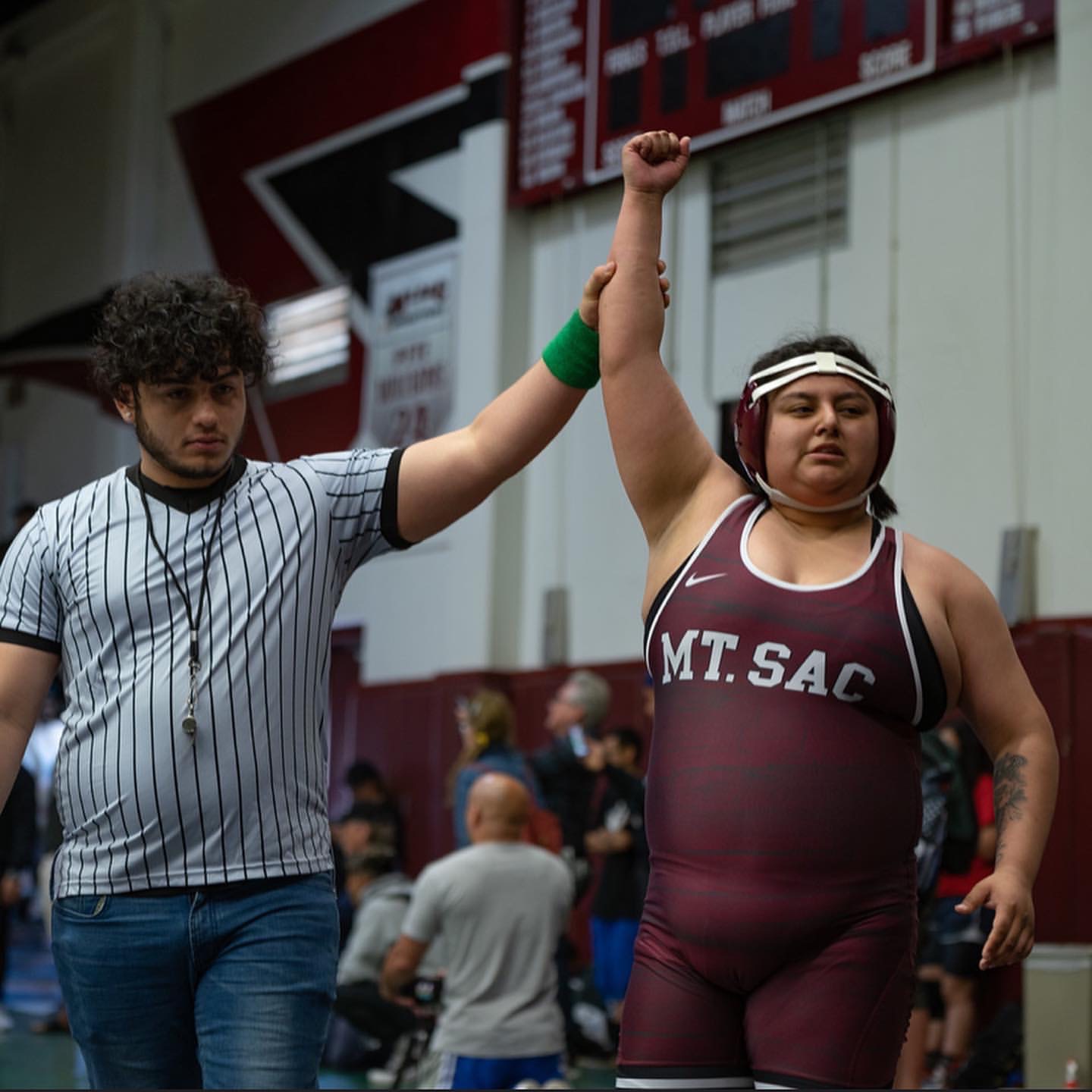 Wrestler holds her arm in air after winning match